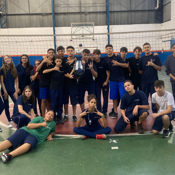 Alunos do Colégio Pentágono com troféu na quadra poliesportiva