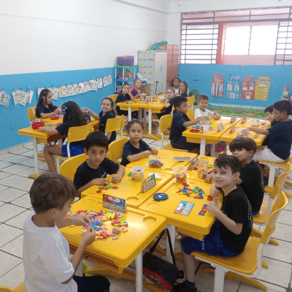 Turma dos Anos Iniciais em atividade prática com materiais nas mesas