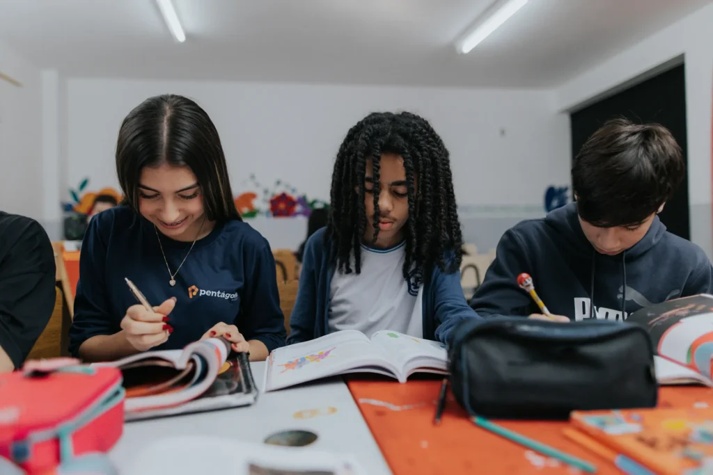 Estudantes do Colégio Pentágono estudando juntos com livros e cadernos